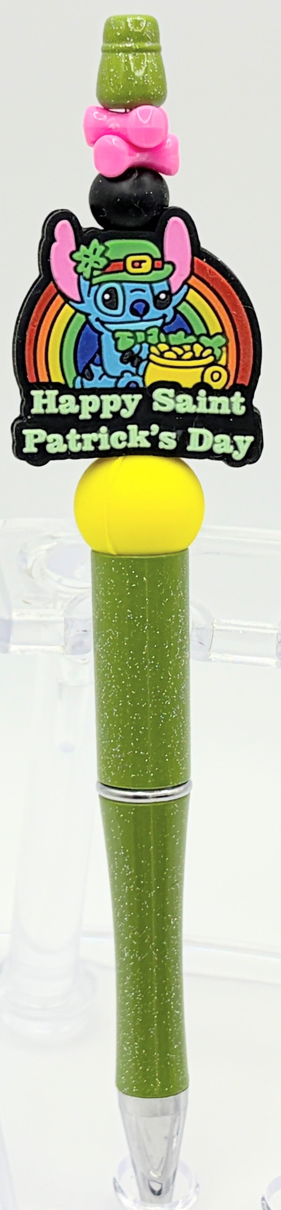 Green pen with rainbow character and 'Happy St. Patrick's Day' text on a white background